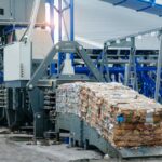 Recycling plant machinery compressing sorted waste into bales.