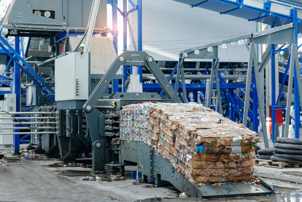 Recycling plant machinery compressing sorted waste into bales.